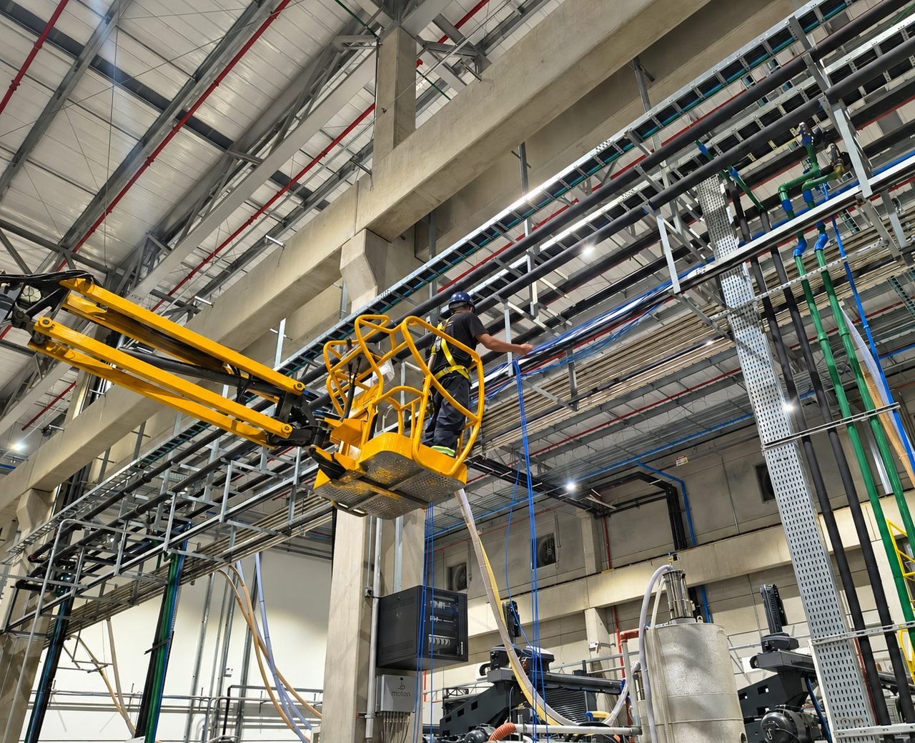 Operador da MB Engenharia em plataforma elevatória instalando infraestrutura de segurança eletrônica e cabeamento
